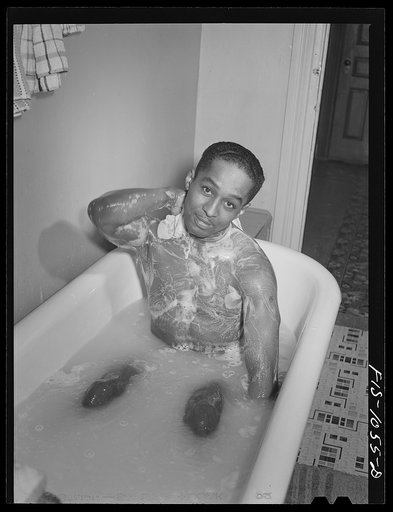 Baltimore, Maryland. Sargeant Franklin Williams, home on leave from Army duty, taking a bath