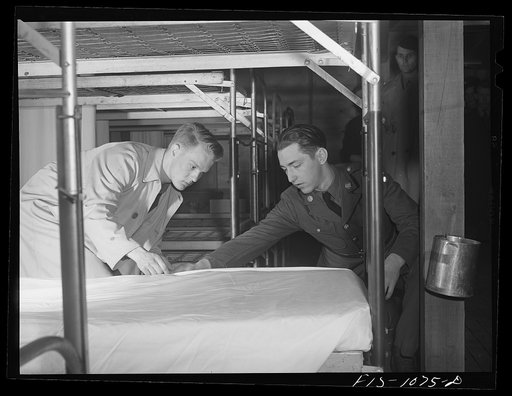 Swedish-American selectee in Minnesota learning how to make a bed as he is inducted into the U.S. Army