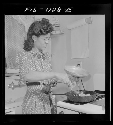 Washington, D.C. Jewal Mazique [i.e. Jewel] cooking dinner after a hard day's work in the Library of Congress