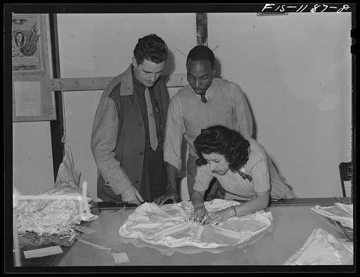 Inspector of the Standard Parachute Company and "Skippy" Smith, manager of the Pacific Parachute Company (subcontractors of Standard Parachute), watch final inspection of pilot parachutes being made at the Pacific Parachute Company. San Diego, California