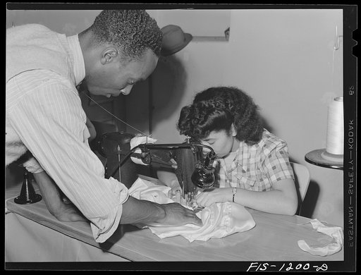 "Skippy" Smith, manager, watching one of the girls working on a pilot parachute at the Pacific Parachute Company. San Diego, California