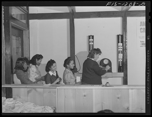 Employees of the Pacific Parachute Company checking in for work. San Diego, California