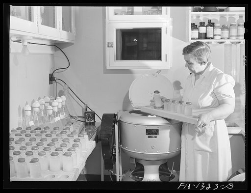 Placing typus vaccine in centrifuging machine. Rocky Mountain Laboratory. Hamilton, Montana