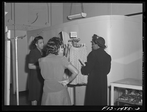 Untitled photo, possibly related to: Miss Dorothea Owens trying on a new skirt in the Rosetta Frocks dress shop which is owned by Miss Cecilia Hall (Negro). Chicago, Illinois