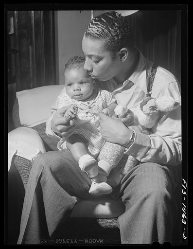 Oliver Coleman with his five-month-old son in the living room of his apartment on Indiana Avenue. Chicago, Illinois
