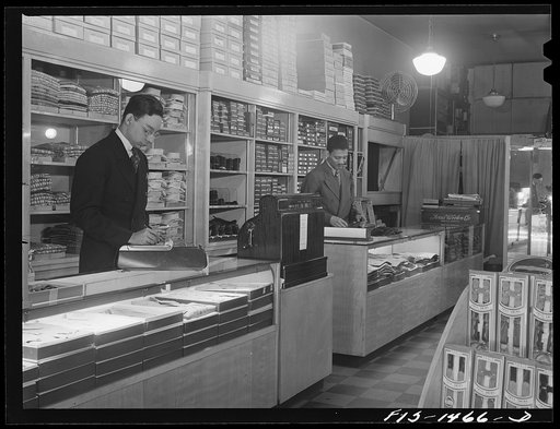 Untitled photo, possibly related to: Mr. William Strong (left), manager of the Henry C. Taylor Store for Men, selling underclothes to Mr. J. Foster. 47th Street near State Street, Chicago, Illinois
