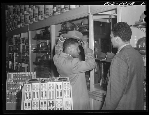 Untitled photo, possibly related to: Mr. Claude Walker trying on a new hat in the Henry C. Taylor Store for Men. The salesman is Mr. William Strong, who is manager of the store. 47th Street near State Street, Chicago, Illinois
