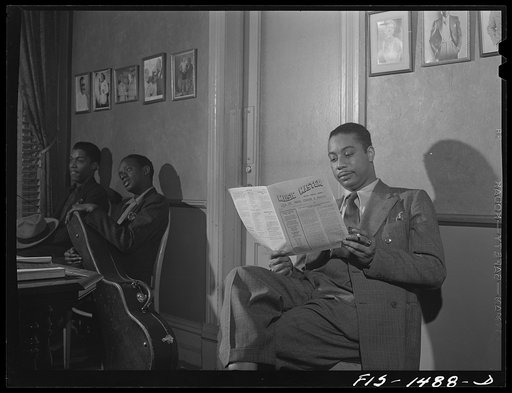 Oliver Coleman in the waiting room at Musicians' Hall, headquarters of local 208 of the musicians' union. He is waiting to see the president. Also waiting are, left to right:  Arthur Harrod and Alvin Bowen, two other members of the union. Mr. Coleman is reading Music Master, the official publication