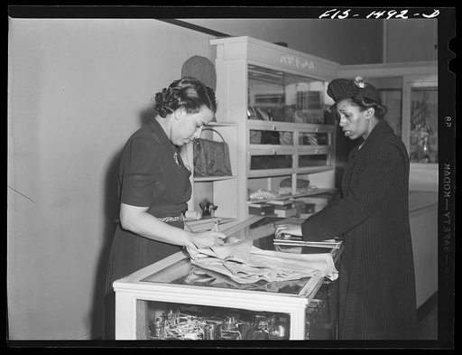 Miss Anita Francois, left, salesgirl in the Rosetta Frocks dress shop, selling a skirt to a customer. Chicago, Illinois