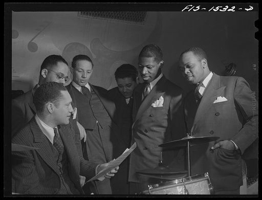 "Red" Sounders [i.e. Saunders] and some of the men in his band getting together to discuss the arrangement of a new number. Club DeLisa, Chicago, Illinois
