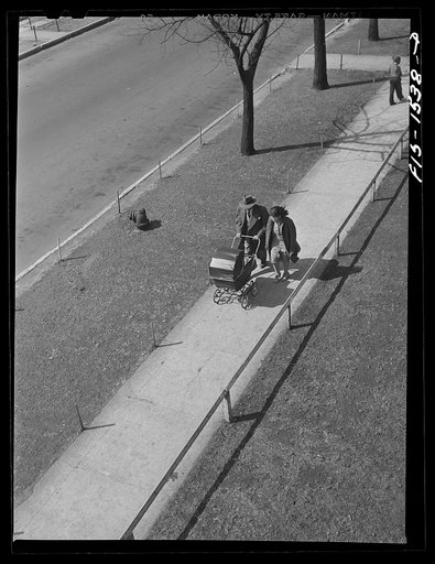 Mr. and Mrs. Oliver Coleman taking their five-month-old son out for some air along Indiana Avenue. Chicago, Illinois