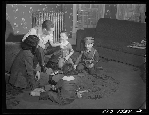 The Sounders [i.e. Saunders] family playing trains with Martin Brown (in soldier suit), a neighbor's child. Chicago, Illinois