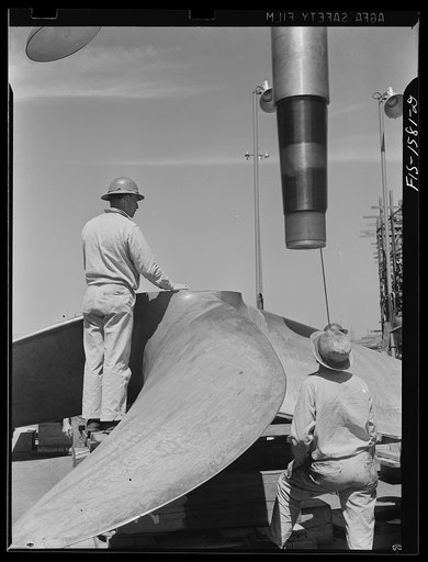 California Shipbuilding Corporation, Wilmington, California. Short section of a drive shaft being hoisted into position for proper fitting into the propeller