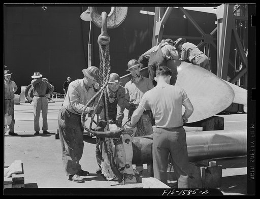 California Shipbuilding Corporation, Wilmington, California. Workmen attaching a hoist to a section of the drive shaft preparatory to swinging it over to be fitted into the propeller