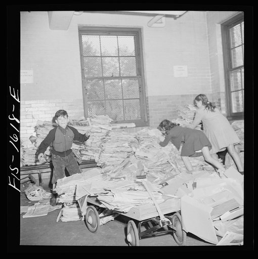 Untitled photo, possibly related to: Washington, D.C. Scrap salvage campaign, Victory Program. Schoolchildren bring their scrap paper from their classrooms into the cellar, where it is picked up by paper company truck
