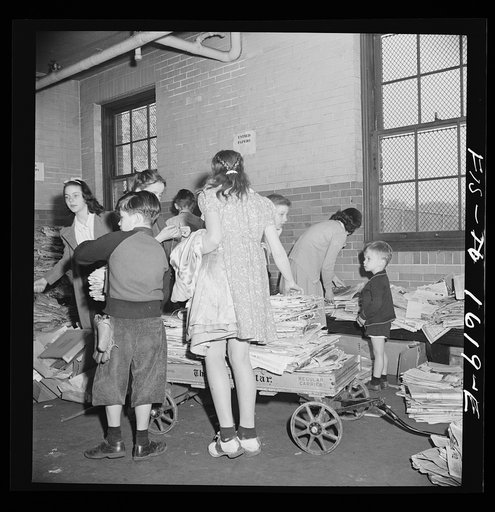 Untitled photo, possibly related to: Washington, D.C. Scrap salvage campaign, Victory Program. Schoolchildren bring their scrap paper from their classrooms into the cellar, where it is picked up by paper company truck