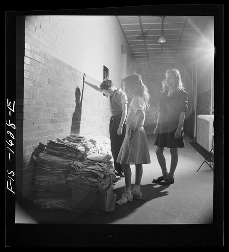 Untitled photo, possibly related to: Washington, D.C. Scrap salvage campaign, Victory Program. After bringing their scrap paper to school, each class stacks their contributions outside the classroom door. Here the student council is shown judging one pile. Classes compete for the greatest amount on 
