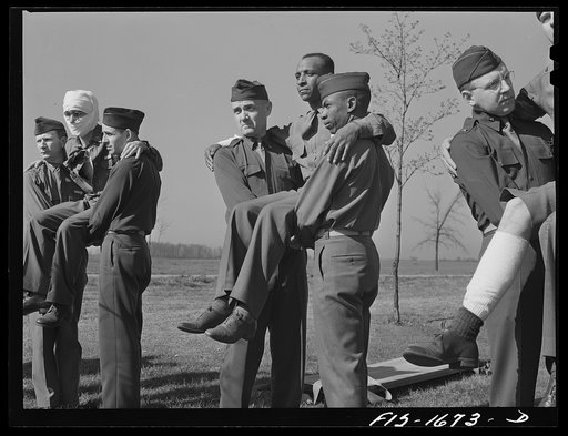 A first aid class at the chaplain school, learning the proper methods of carrying the wounded. U.S. Army chaplain school, Fort Benjamin Harrison, Indiana