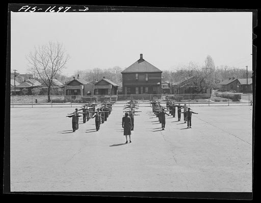 Negro school children of the Military Officers' Training Corps marching in formation for Chaplain George W. Williams, a graduate of the Chaplain School. The MOTC was organized at the school by the teachers for those youngsters who wanted some preparation for future military service. U.S. Army Chapla