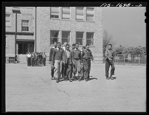 Untitled photo, possibly related to: Negro schoolchildren of the Military Officers' Training Corps marching in formation for Chaplain George W. Williams, a graduate of the U.S. Army chaplain school at Fort Benjamin Harrison, Indiana. The MOTC was organized at the school by the teachers for those you