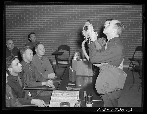 Student learning the proper method of wearing a gas mask at the U.S. Army chaplain school. Fort Benjamin Harrison, Indiana