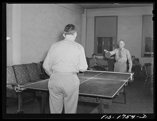 Untitled photo, possibly related to: Chaplain (Major) P.M. Hickcox, and Chaplain (Major) P.L. Cronin, playing a game of ping-pong in the recreation hall of the U.S. Army chaplain school. Fort Benjamin Harrison, Indiana