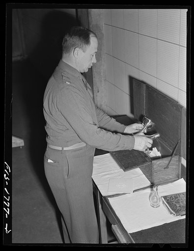 Chaplain (Major) P.S. Hall, Episcopalian, of Upper Darby, Pennsylvania packing his "mass kit." This kit was dedicated by Bishop Tucker of the Holy Trinity Church of Philadelphia, and is the authorized official field altar for Episcopal chaplains. U.S. Army chaplain school, Fort Benjamin Harrison, In
