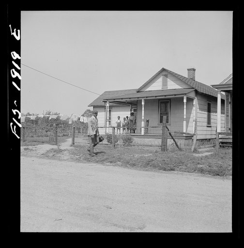 Newport News, Virginia. Negro shipyard worker leaving his rural home for the shipyards with his lunch box