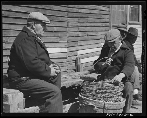 Untitled photo, possibly related to: Provincetown, Massachusetts. Portuguese dory fisherman coiling down his trawl for the next day's fishing