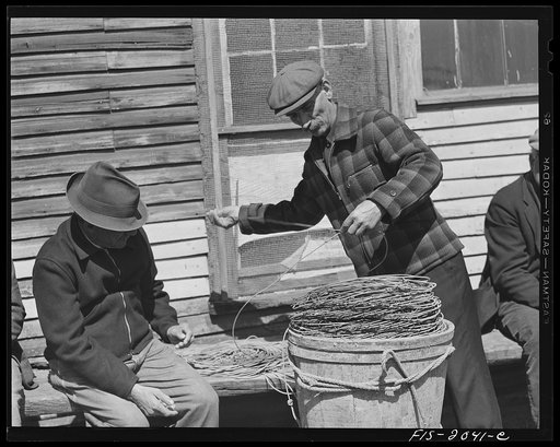 Untitled photo, possibly related to: Provincetown, Massachusetts. Portuguese dory fisherman coiling down his trawl for the next day's fishing