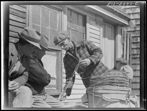 Untitled photo, possibly related to: Provincetown, Massachusetts. Portuguese dory fisherman coiling down his trawl for the next day's fishing