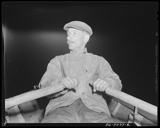 Provincetown, Massachusetts. Portuguese dory fisherman rowing out to his boat at 4:30 in the morning to leave for the banks off Cape Cod