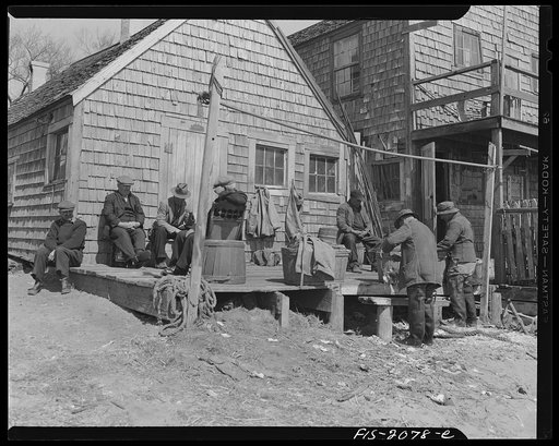 Provincetown, Massachusetts. Portuguese dory fisherman gossiping in front of their fishing shack, where they store their gear