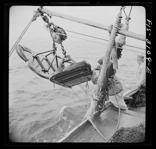 Provincetown, Massachusetts. Aboard the Frances and Marion, a Portuguese drag trawler, fishing off Cape Cod. "Doors," which when lowered, slide over the bed of the ocean like sled runners, dragging behind them the purse seine which scoops up miscellaneous fish, rocks, crabs, lobsters, and a great de