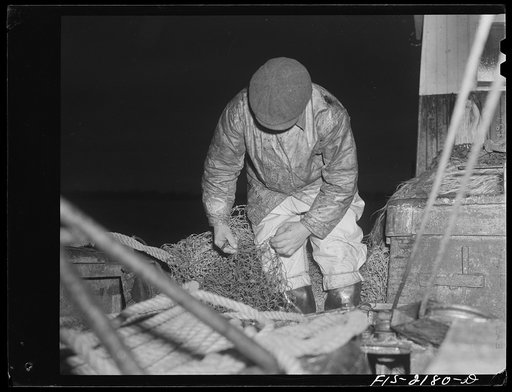 Provincetown, Massachusetts. Mending nets at dawn aboard the Portuguese trawler, Frances and Marion