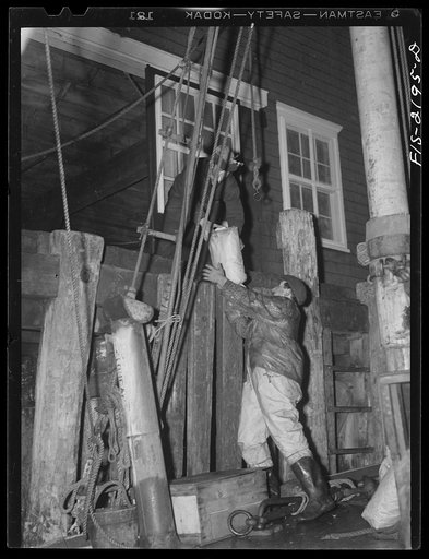 Provincetown, Massachusetts. Before putting to sea for the day's trawl, the fishing boats take on food from deliverymen waiting on the wharfs