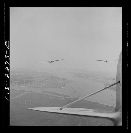 Parris Island, South Carolina. U.S. Marine Corps glider detachment training camp. An aerial "tug boat" tows three gliders high above the field