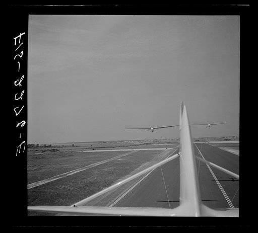 Parris Island, South Carolina. U.S. Marine Corps glider detachment training camp. An aerial "tug boat" tows three gliders high above the field