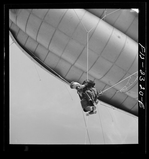 Pat Terry, photographer taking pictures while suspended from a barrage balloon at the US Marine glider detachment training camp, Parris Island, South Carolina