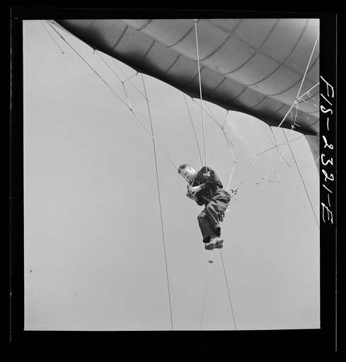 Pat Terry, photographer taking pictures while suspended from a barrage balloon at the US Marine glider detachment training camp, Parris Island, South Carolina