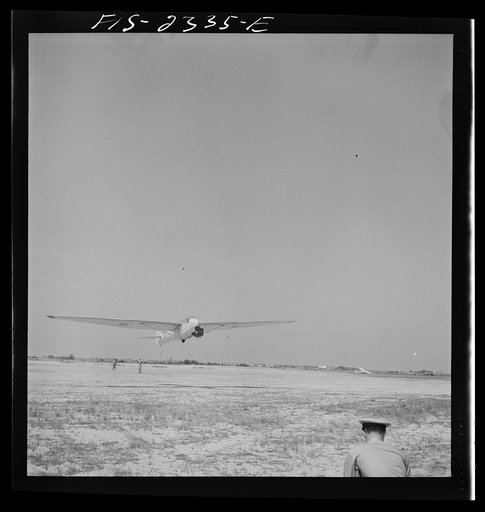 Parris Island, South Carolina. A glider plane being towed over a field at the U.S. Marine Corps glider detachment training camp