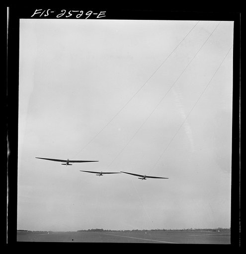 Parris Island, South Carolina. U.S. Marine Corps glider detachment training camp.  An aerial "tug boat" tows three gliders high above the field