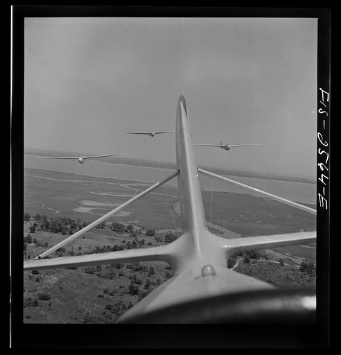 Parris Island, South Carolina. U.S. Marine Corps glider detachment training camp. An aerial "tug boat" tows three gliders high above the field