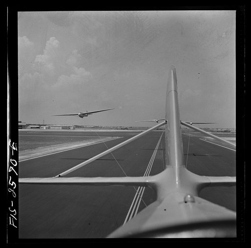Parris Island, South Carolina. U.S. Marine Corps glider detachment training camp. An aerial "tug boat" tows three gliders high above the field