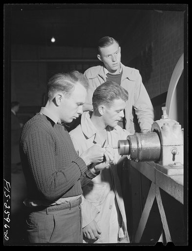 Group of students in agricultural engineering conducting a brake test on a power machine. In agriculture engineering building, Iowa State College. Ames, Iowa