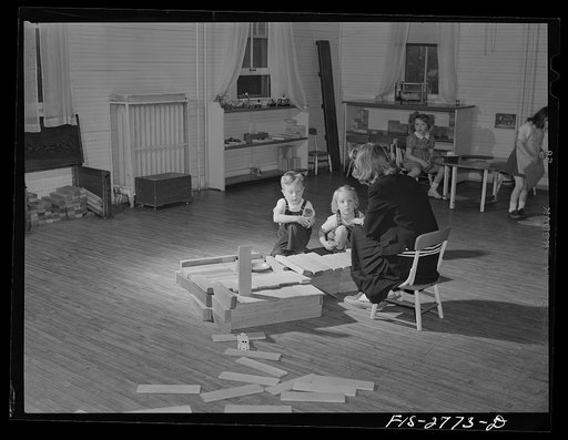 Graduate student looking after children in the nursery at Iowa State College. Ames, Iowa