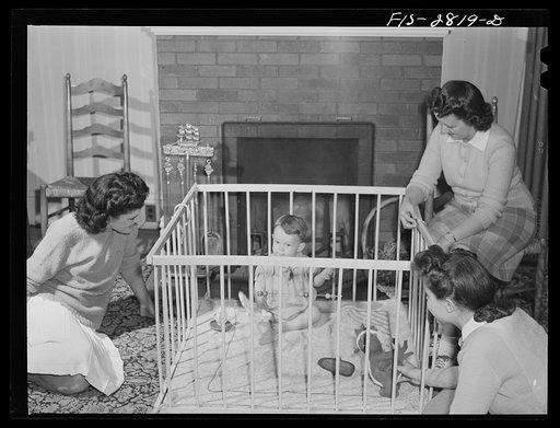Home economics students looking after the child that lives with them in one of the home management houses at Iowa State College. Ames, Iowa