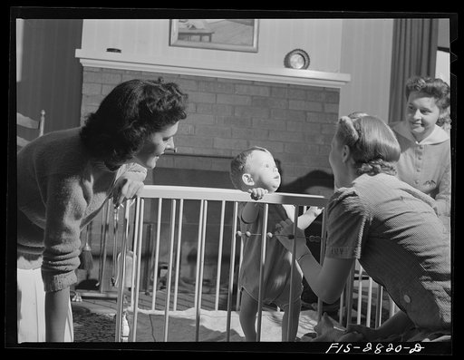 Home economics students looking after the child that lives with them in one of the home management houses at Iowa State College. Ames, Iowa