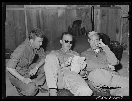Group of Sergeant pilots (Flying Sergeants) look at the map trying to decide where to go on weekly twenty-four hour leave