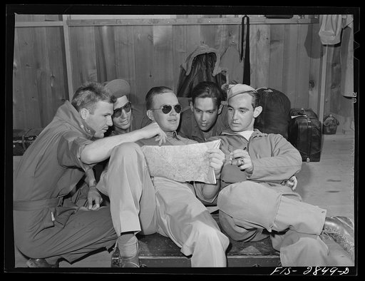 Group of Sergeant pilots (Flying Sergeants) look at the map trying to decide where to go on weekly twenty-four hour leave